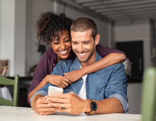 a man and woman looking at a cell phone