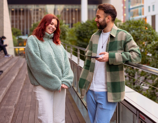a man and a woman talking while the man holds a phone