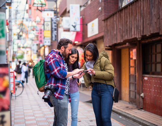 international travelers in japan on their phone 