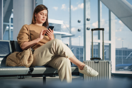 A woman is sitting at the Tokyo airport looking at her phone